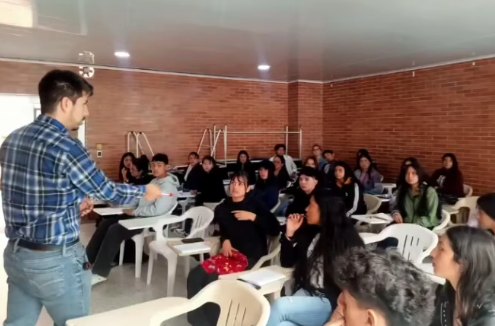 Tallerista frente al salón lleno de estudiantes