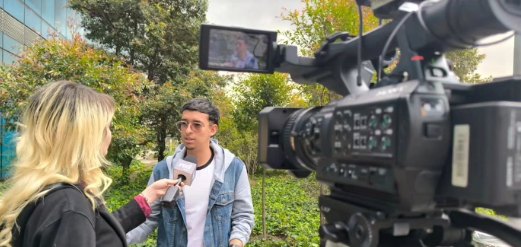 Estudiante siendo entrevistado frente a una cámara de televisión