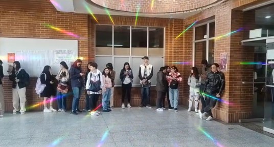 Fila de estudiantes esperando en el corredor del colegio